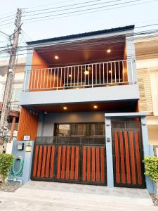 a house with red doors and a balcony at THE MAISON Phuket in Ban Lo Long