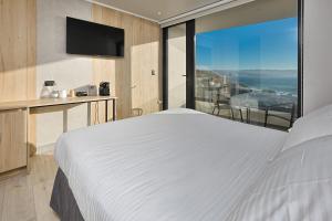 a bedroom with a large white bed and a large window at Arka Hotel in Viña del Mar