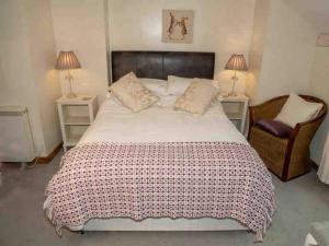 a bedroom with a large bed and a chair at Cwm Ffernol in Machynlleth
