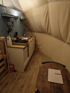 a room with a table and a kitchen in a tent at Cherry Tree Dome in Smeeth +22 photos
