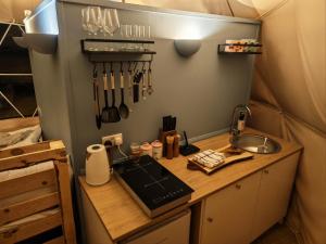 a kitchen in a tent with a sink and utensils at Cherry Tree Dome in Smeeth