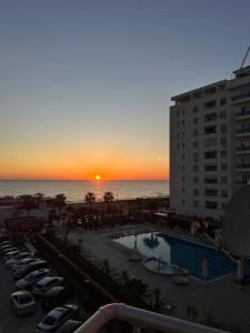 a sunset over a parking lot with a pool at Arli's SeaFront Apartaments in Durrës