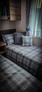 a bed in a bedroom with a plaid bedsheet at K&S at 1529 in Selsey +49 photos