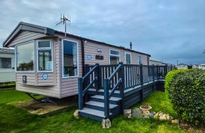 a tiny house with a blue staircase in a yard at K&S at 1529 in Selsey