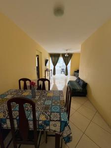 a dining room with a table and a couch at Apartamento do Lala in Arraial do Cabo
