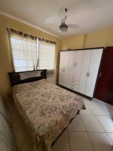 a bedroom with a bed and white cabinets and a fan at Apartamento do Lala in Arraial do Cabo