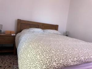 a bedroom with a bed with a wooden head board at Lilac House Kefalonia in Ratzaklíon +7 photos