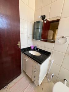 a bathroom with a sink and a mirror at Apartamento do Lala in Arraial do Cabo +40 photos