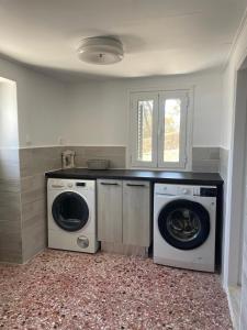 a laundry room with a washer and dryer at Lilac House Kefalonia in Ratzaklíon
