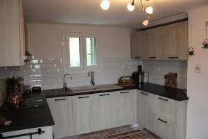 a kitchen with white cabinets and a sink at Lilac House Kefalonia in Ratzaklíon