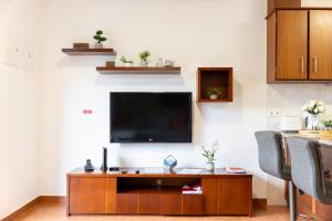 a living room with a flat screen tv on a wall at Furnas Panorama House in Furnas