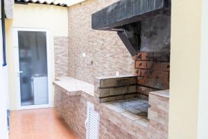 a kitchen with a brick wall with a stove at Furnas Panorama House in Furnas +37 photos