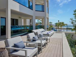 a row of white lounge chairs on a patio at Hawar Resort By Mantis in Hawar Island