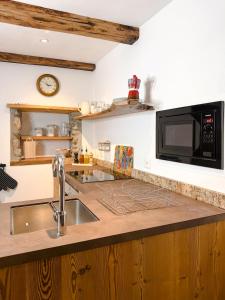 a kitchen with a sink and a microwave at Appartamento LA ROSA in Ponto Valentino