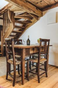 a wooden table with chairs and a bottle of wine at Appartamento LA ROSA in Ponto Valentino