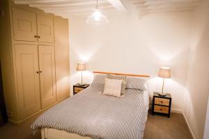 a bedroom with a bed with two night stands and two lamps at Spacious 4 Bed House Sleeps 8 in Quorn Near Loughborough in Quorndon