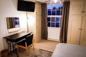 a bedroom with a desk and a bed and a window at Spacious 4 Bed House Sleeps 8 in Quorn Near Loughborough in Quorndon +2 photos