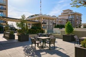 a patio with tables and chairs in front of a building at STYLO Residences & Suites in Tashkent
