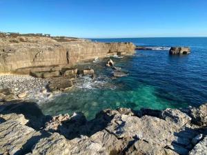 a body of water with rocks and the ocean at Apartment 2 Maritime House in Portland +4 photos