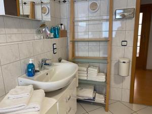 a bathroom with a sink and a bunch of towels at Privatquartier im Ortskern von Westerstede in Westerstede