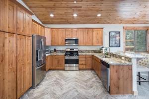 a kitchen with wooden cabinets and stainless steel appliances at The Speckled Gem in Kings Beach