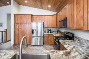 a kitchen with wooden cabinets and a stainless steel refrigerator at The Speckled Gem in Kings Beach +44 photos
