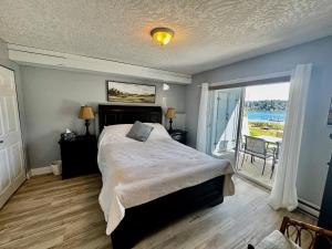 a bedroom with a large bed and a balcony at Lakefront Condo and Beach in Shawnigan Lake +28 photos