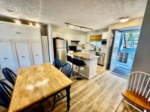 a kitchen with wooden tables and chairs in a room at Lakefront Condo and Beach in Shawnigan Lake