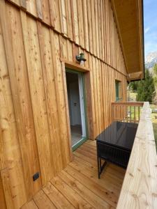 a wooden building with a table on a deck at Villa Lidl Ferienwohnung in Altaussee