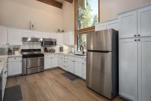 a kitchen with white cabinets and a stainless steel refrigerator at Sandy Shores Villa in Tahoe Vista