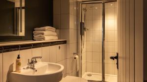 a bathroom with a sink and a shower at The Exeter Inn in Bampton