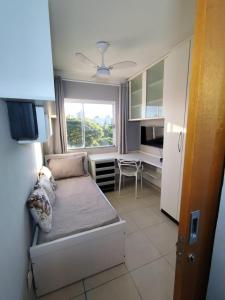 ein kleines Schlafzimmer mit Bett und Schreibtisch in der Unterkunft Apartamento em Maringá zona 07, próximo da universidade UEM in Maringá