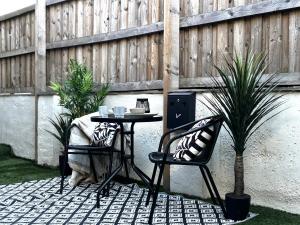 a table and two chairs sitting next to a fence at Holdsworth House Apartments in Killingbeck