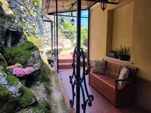 a porch with a bench and a stone wall at Casa Mafalda in Campiglia