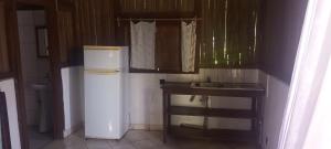 a small kitchen with a refrigerator and a sink at Bungalow Frédéric in Hell-Ville