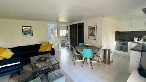 a living room with a couch and a table and chairs at Le Lodge du Touquet in Le Touquet-Paris-Plage