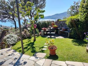 a garden with a table and benches and flowers at L'Alcova tra gli ulivi in Zoagli