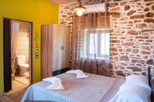 a bedroom with a bed with two towels on it at Oliva Mare II in Agia Fotia