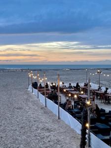 a group of people sitting at tables on the beach at Le Lodge du Touquet in Le Touquet-Paris-Plage +13 photos