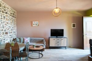 a living room with a couch and a tv at Oliva Mare II in Agia Fotia