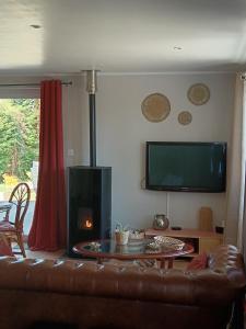 a living room with a couch and a fire place at Le clos des papillons in Carly