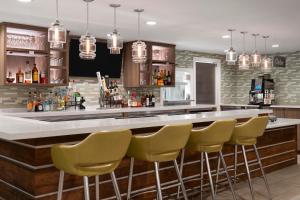 a bar with yellow bar stools in a room at EVEN Hotel Ann Arbor S - University Area by IHG in Ann Arbor