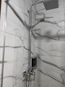 a shower in a bathroom with white marble walls at Apartament DAR25 in Sînmartin +20 photos