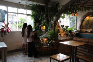 two girls standing in a restaurant looking at an aquarium at Hotel Grand ilama in Cali