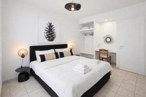 Ein weißes Schlafzimmer mit einem großen Bett und weißer Bettwäsche. in der Unterkunft Koukounari Apartments in Skala