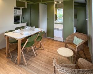 a kitchen and dining room with a table and chairs at Camping Le Neptune in Lanloup