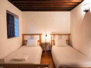 two beds in a room with white walls at Quinta de Segade in Santa Marta