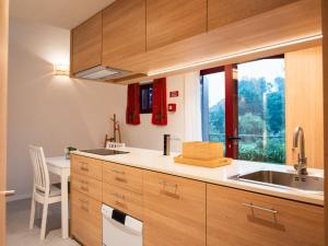 a kitchen with wooden cabinets and a sink and a desk at Quinta de Segade in Santa Marta +4 photos