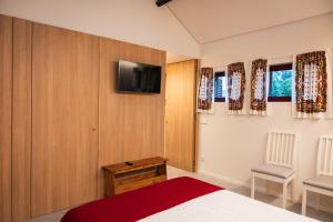 a bedroom with a bed and a tv on the wall at Quinta de Segade in Santa Marta