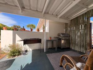 an outdoor patio with a grill and a piano at Cosy Coastal Hideaway in Hermanus